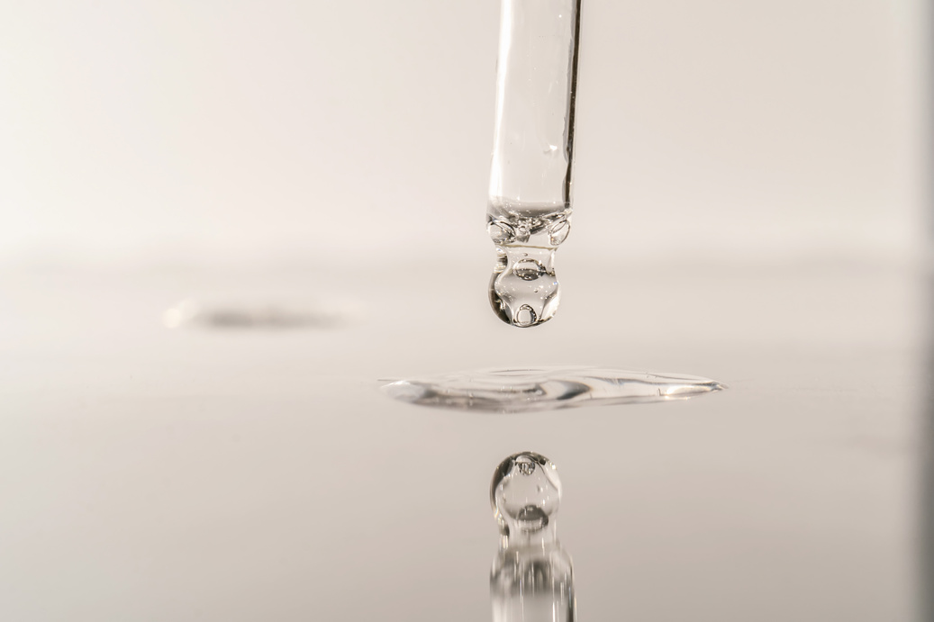 The Texture of Serum or Oil with a Pipette on a Grey Background.